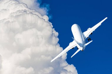 Mavi bir gökyüzü ve pitoresk bulutlarda uçan bir uçak