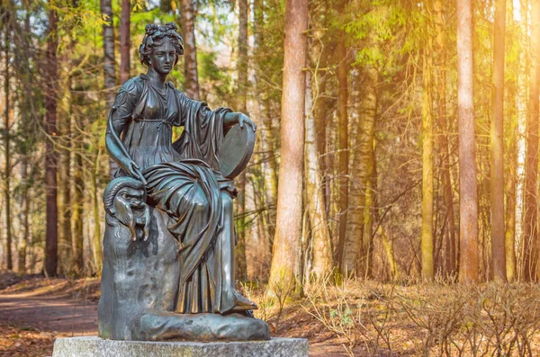 Жіноча мідна статуя божества з арфою в лісі — стокове фото