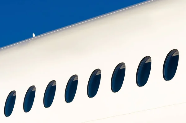 Okénka na bílé moderní letadla a obloha — Stock fotografie