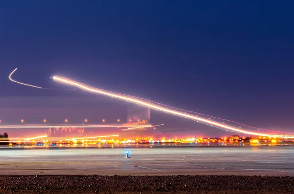Ночные огни, следы огней в движении самолета на длительной экспозиции — стоковое фото