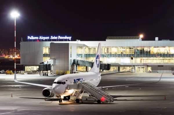 Vista nocturna del aeropuerto y el avión de la aerolínea UTair. Rusia, San Petersburgo abril 2017 . — Foto de Stock