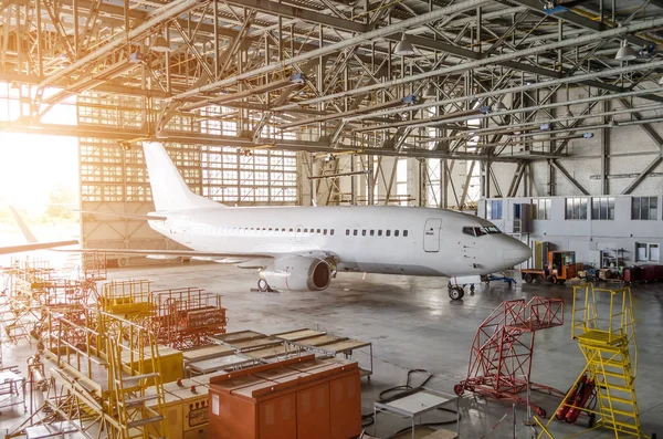 Aviones de línea aérea en un hangar con una puerta abierta al servicio . —  Fotos de Stock