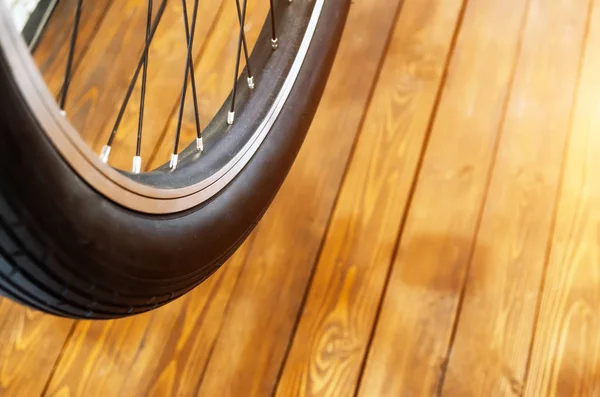 Rad eines stylischen Fahrrades mit schwarzer Felge und schwarzem Gummireifen auf stilvollem Holzhintergrund. — Stockfoto