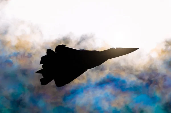 太陽と虹の雲の背景に対して軍の戦闘機のシルエット. — ストック写真