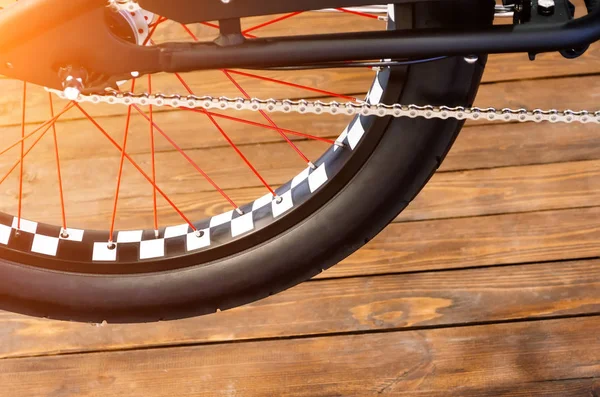 Rad eines stylischen Fahrrades mit schwarz-weißer Felge und schwarzem Gummireifen auf stylischem Holzhintergrund. — Stockfoto