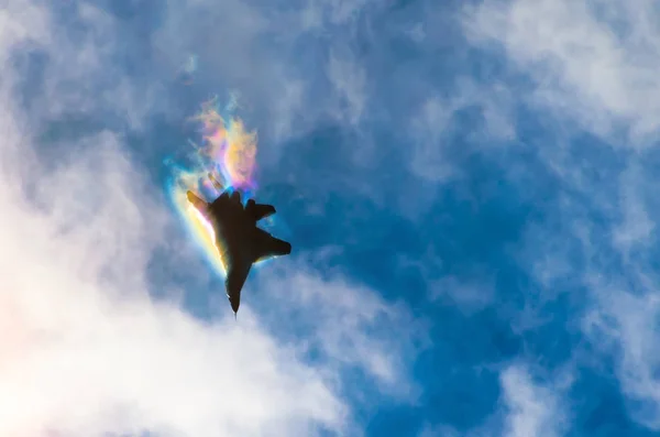 Um combatente militar no céu, a perfurar nuvens de pausas de vapor, luz do arco-íris . — Fotografia de Stock