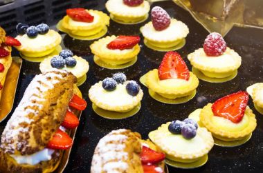 Kek ve çilek, yaban mersini ve pudra şekeri sepetleri.