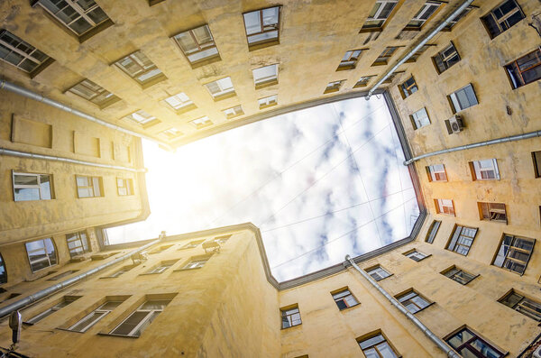 Rectangular closed yard old houses wells in St. Petersburg sky and light