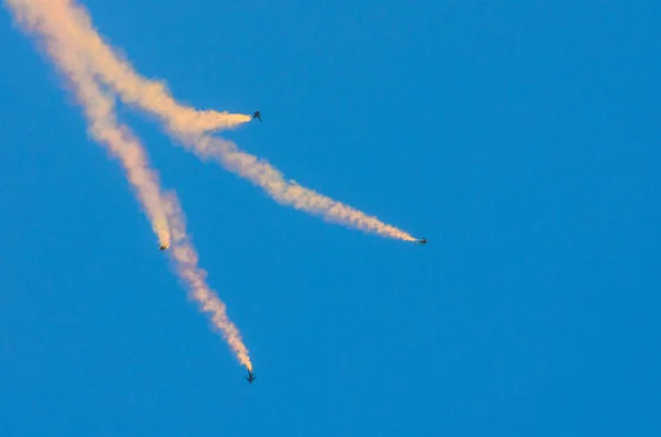Paracaidistas cuatro saltan con humo y vuelan en el cielo azul . — Foto de Stock