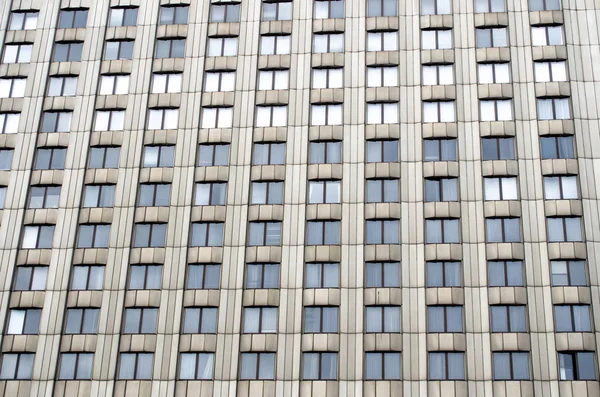 Muitas janelas um edifício urbano alto de cor monofônica — Fotografia de Stock