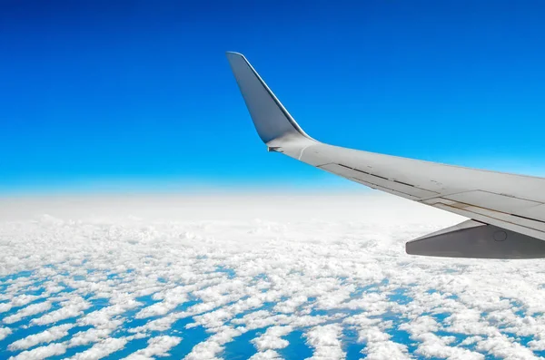 Beautiful classic view of the porthole during a flight by plane, clouds of blue sky and earth