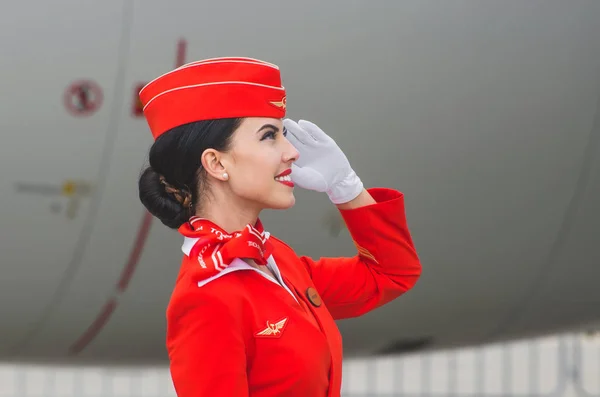 Okouzlující letuška oblečená v červených uniformách. Rusko, Moskva. Červenec 2017 — Stock fotografie