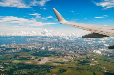 Lombar şehir ve Havaalanı ile pitoresk bulutlar uçak kanadının görünümü