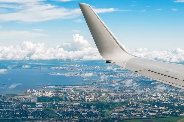 Lombar şehir ve Havaalanı ile pitoresk bulutlar uçak kanadının görünümü