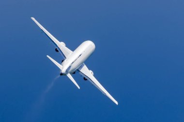 Mavi gökyüzünde yağmurda beyaz uçak çıkartıyor