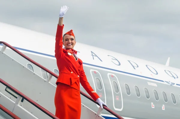 Okouzlující letuška oblečená v červených uniformách. Rusko, Saint-Petersburg. 10 srpen 2017 — Stock fotografie