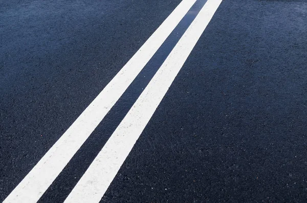 Linha branca contínua dobro no asfalto molhado — Fotografia de Stock