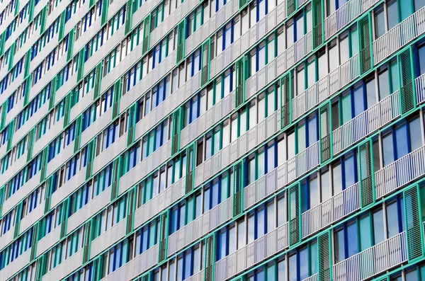 Balconies and windows of a building, apartment houses textured beige green lattices — Stock Photo, Image