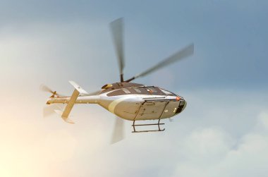 Bulutlu bir günde gökyüzünde uçan helikopter döner