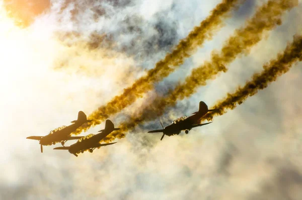 Grupo de aviones turbohélice blancos con un rastro de humo blanco contra un cielo azul —  Fotos de Stock