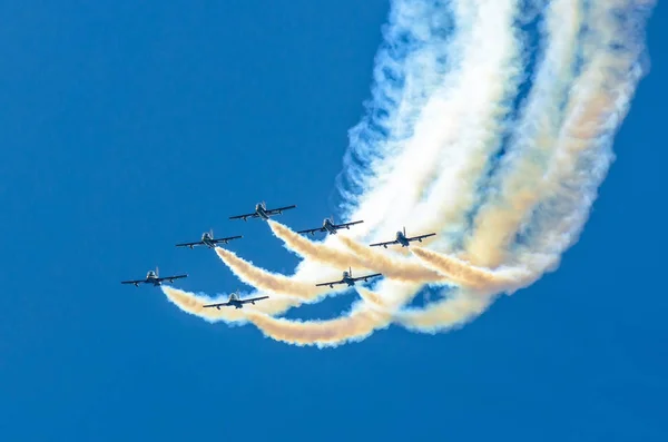 Skupina bílých stíhačce letadla s nádechem bílého kouře proti modré obloze — Stock fotografie
