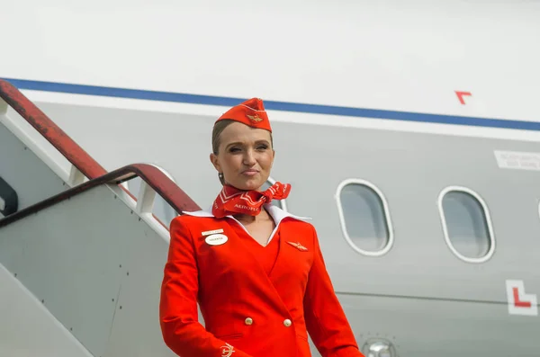 Okouzlující letuška oblečená v červených uniformách. Rusko, Saint-Petersburg. 10. srpna 2017 — Stock fotografie