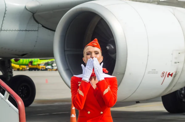 Okouzlující letuška oblečená v červených uniformách. Rusko, Saint-Petersburg. 10. srpna 2017 — Stock fotografie