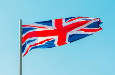 Mavi gökyüzünde renkli Büyük Britanya bayrağı sallayarak