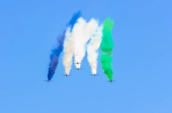 Grupo de caças avião a jato com um traço de fumaça branca contra um céu azul — Fotografia de Stock