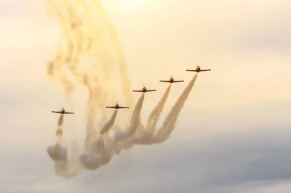 Groupe d'avions de chasse avec une trace de fumée blanche contre un ciel bleu — Photo