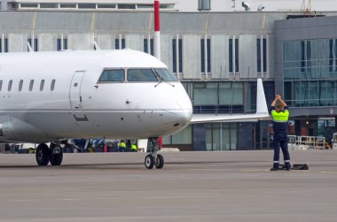 Bir Havaalanı trafiği denetleyicisi yer ekibi bir uçak bir Havaalanı pist rehberlik