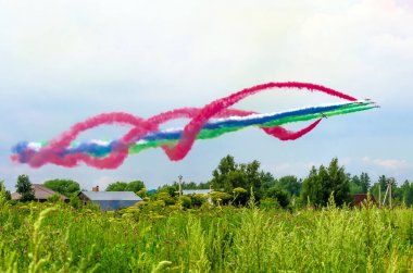 Group of fighter jet airplane with a trace of colorful smoke against sky clipart