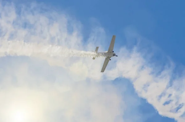 白い青い空を背景に煙の跡と白いターボプロップ飛行機 — ストック写真