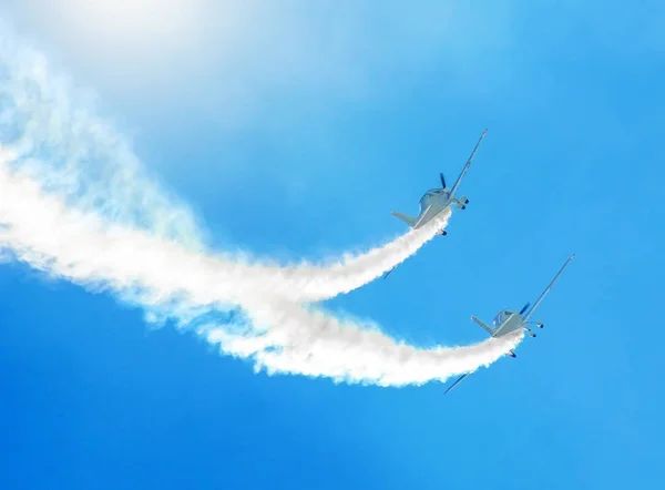 2 つの白い白い青い空を背景に煙のトレースとターボプロップ飛行機 — ストック写真