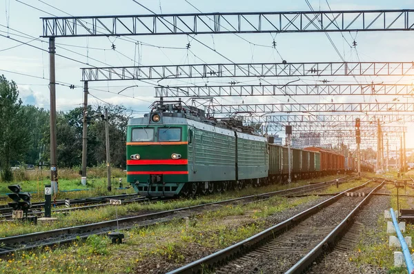 Freight train green with cargo cars on the railway