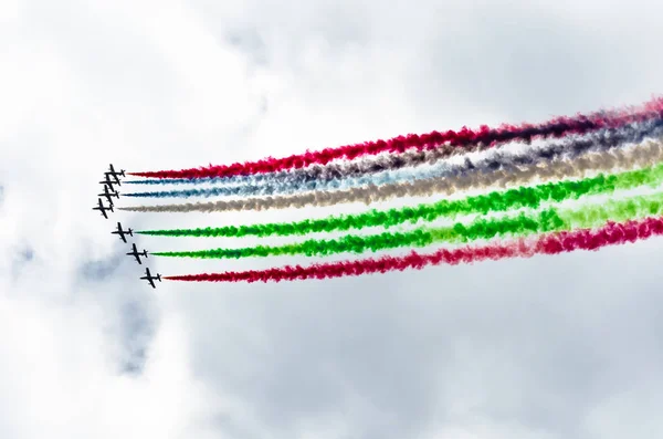 青い空を背景にカラフルな煙の跡と白い戦闘機飛行機のグループ — ストック写真