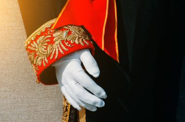 Erkekler tarihi giyim kırmızı ve altın desenli insets kabında, beyaz eldiven bir el ile siyah