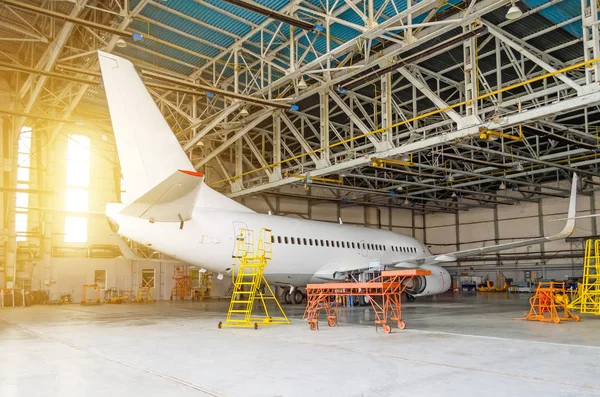 Aviones de línea aérea en un hangar con una puerta abierta al servicio . —  Fotos de Stock