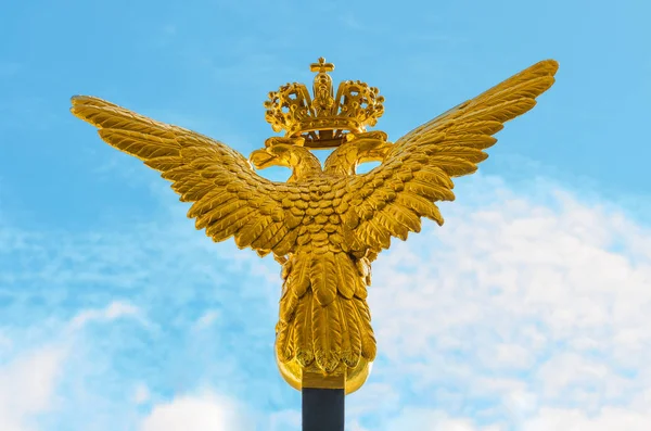 Águila dorada de dos cabezas sobre fondo azul del cielo — Foto de Stock