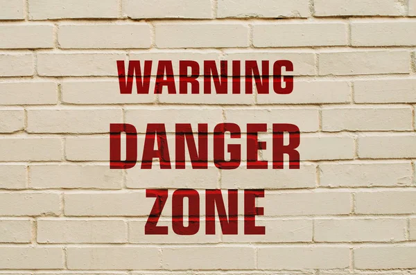 Inscription Warning danger zone on a brick wall — Stock Photo, Image