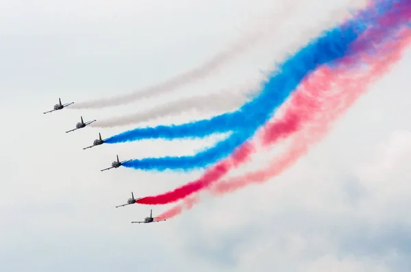 戦闘機が飛ぶ青い空のアクロバット飛行の煙 — ストック写真