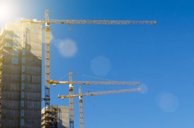 Mavi gökyüzüne karşı konut inşaat yüksek Vinçler