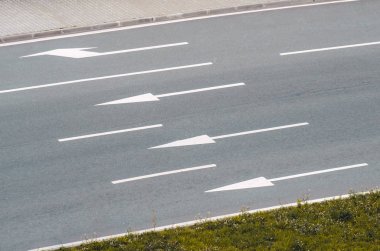 Asfalt yol ve işaretler ve okları ile üç şerit