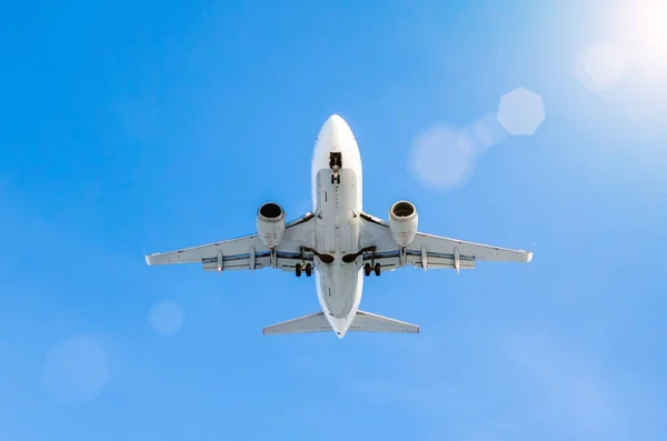 Avión blanco de pasajeros aterrizando en el aeropuerto en el cielo azul — Foto de Stock