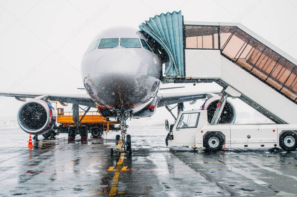Aircraft parked at the airport during bad weather and snow