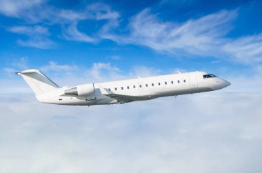 Uçuş seviyesi bir arka plan mavi bir gökyüzü ve bulutlar üzerinde yolcu uçak uçar