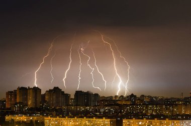 Gece şehir üzerinde şimşek fırtına fırtına
