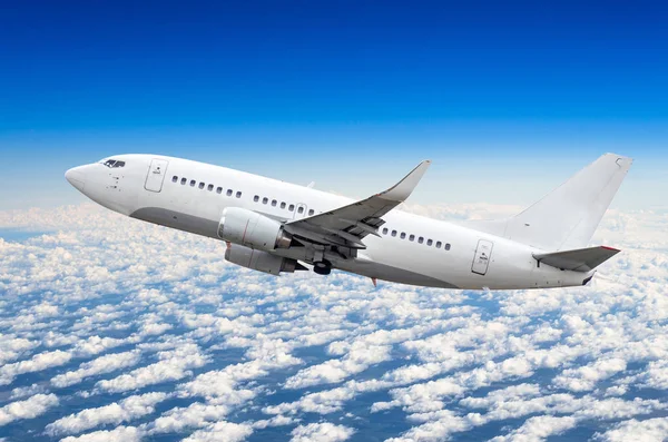 Gökyüzündeki bulutların üstünde yükseklik kazanıyor yolcu uçak uçar