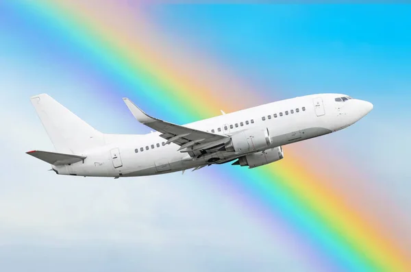 Escalada de un avión contra un arco iris en el cielo — Foto de Stock