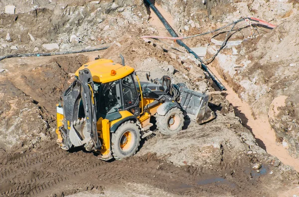 Escavadeira trator com passeios de balde correndo através de terras lama configuração, vista da altura — Fotografia de Stock
